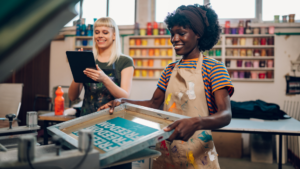 Deux femmes travaillant sur de la communication print et digitale en imprimerie