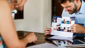 Un homme montrant son dépliant professionnel à une cliente